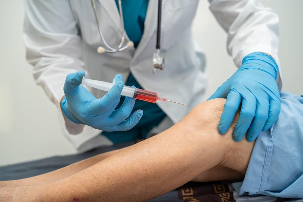 Doctor administering a PRP injection into a patient